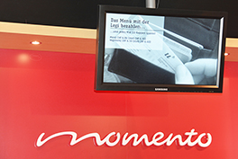 Mensa Gesellschaftsstrasse/Innenansicht/rote Wand/Momento Schriftzug/Screen