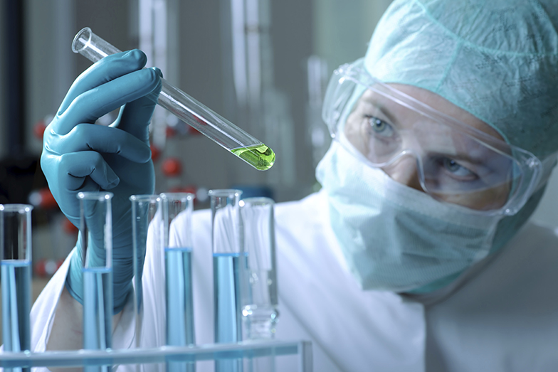 Forschung/Labor/Reagenzglas/Forscher mit Maske und Schutzbrille untersucht Substanz