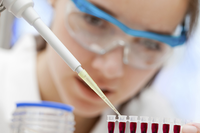 Forschung/Frau mit Schutzbrille/Pipette/Reagenzgläser