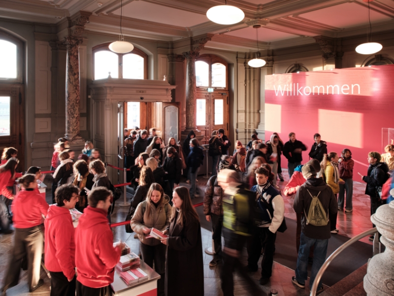 Studierende stehen beim Check-In der Bachelorinformationstage in der Eingangshalle des Hauptgebäudes.