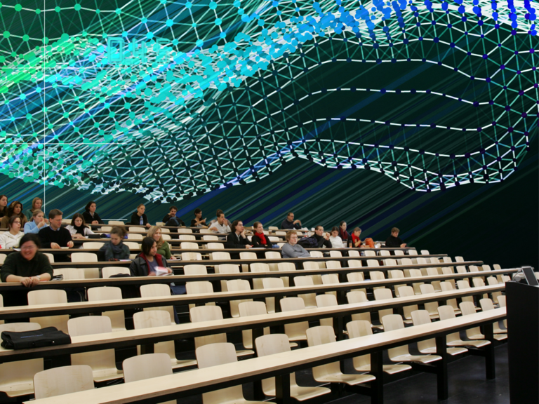 Students sit in the lecture hall and are connected by drawn lines.