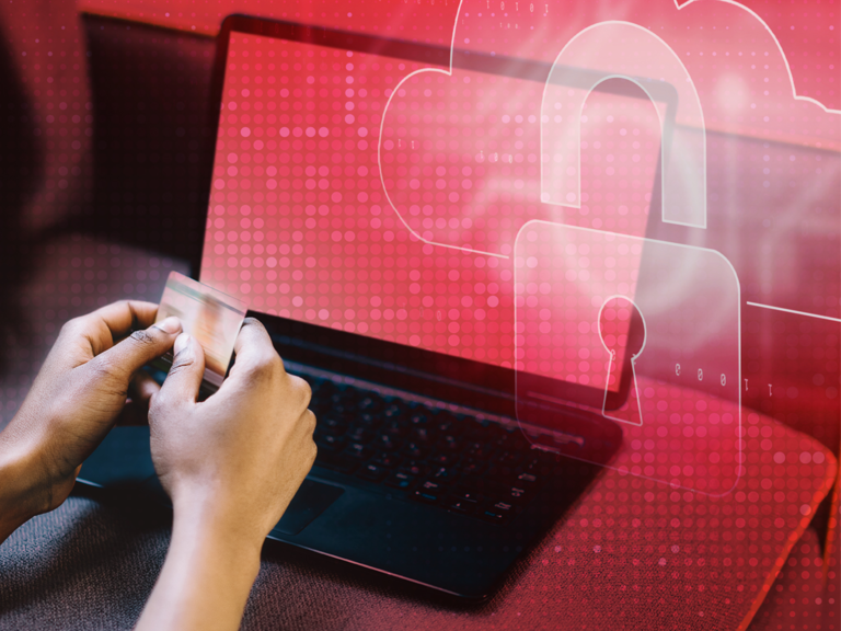 Person sitting with a credit card in front of a laptop, with a red padlock symbol hovering above it.