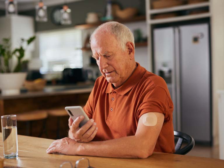 Mann misst seinen Blutzucker mit Smartphone